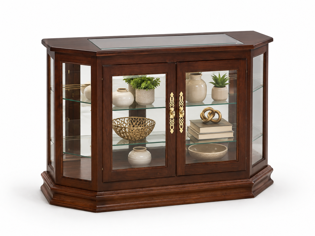 A corner display cabinet with a dark brown wood finish, featuring glass doors with ornate gold handles and interior glass shelves displaying decorative vases, books, and plants, set against a plain white background.