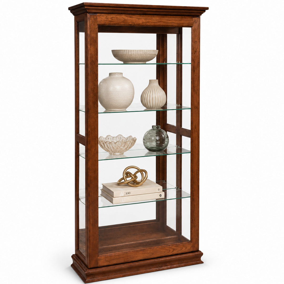 A tall wooden display cabinet with glass shelves, shown against a plain white background. The cabinet is filled with decorative vases, bowls, and books.