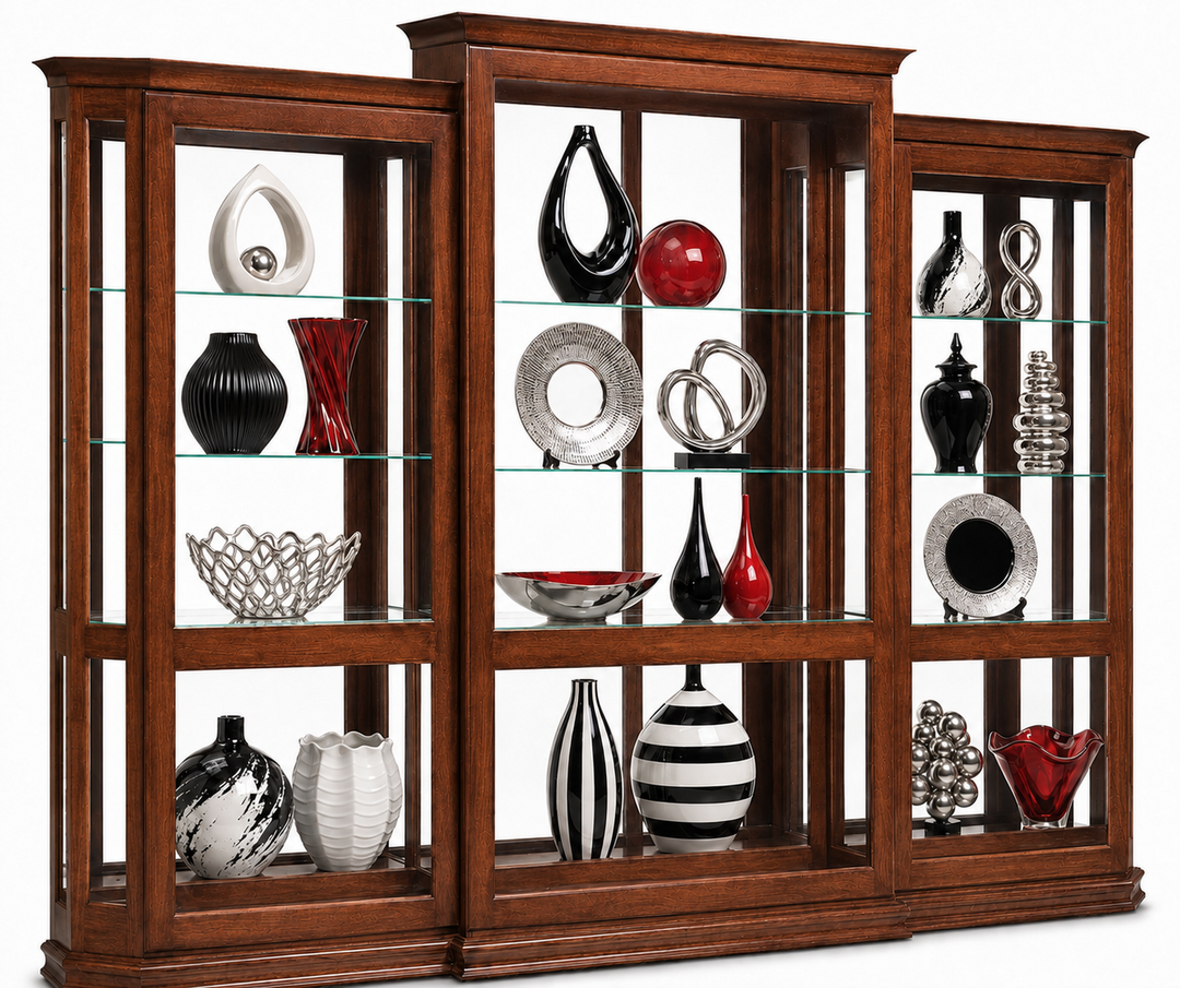 A tall wooden display cabinet with three side panels and a central panel, featuring glass shelves and displaying an assortment of decorative vases, bowls, and plates in black, white, red, and silver.