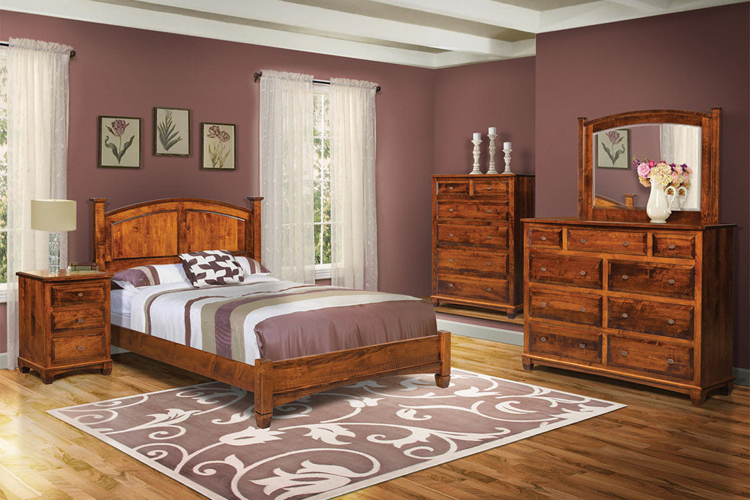 Wooden bedroom furniture set including bed, dresser, and mirror in a room with purple walls and a rug.